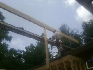 Carpenter setting a ridge beam over a new addition frame — Ice Dam Removal by Roofing Brothers in Fort Smith