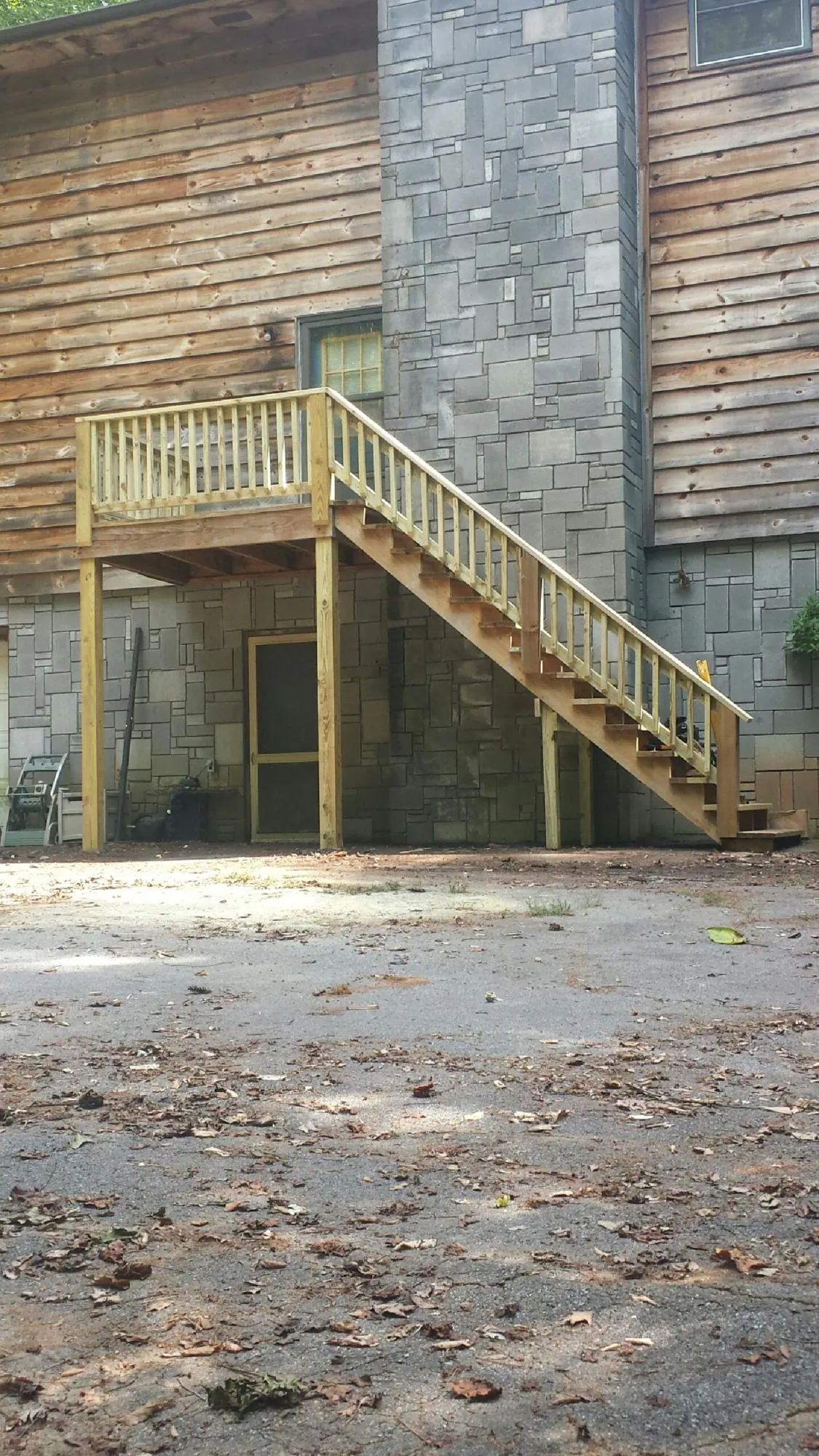 New pressure treated deck and stair landing on a log home in Fort Smith