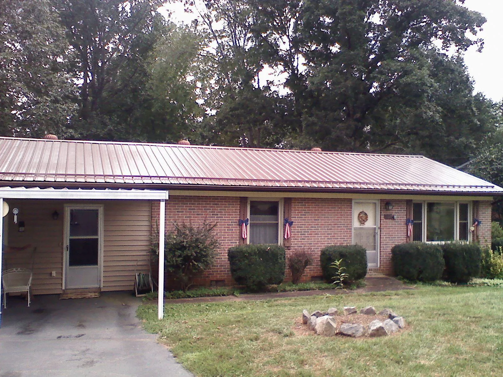 Bronze metal roof and carport on a brick ranch home — Roof Repair work by our crew in Fort Smith