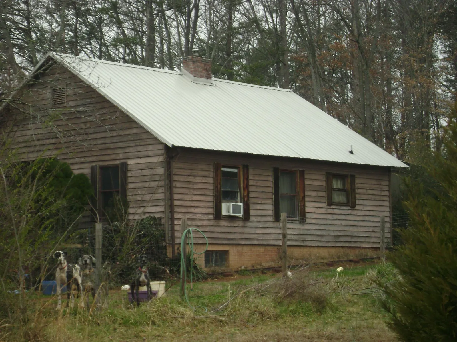 White metal roof on an old wood sided farmhouse, from a Asphalt Shingle Roof Repair job in Fort Smith